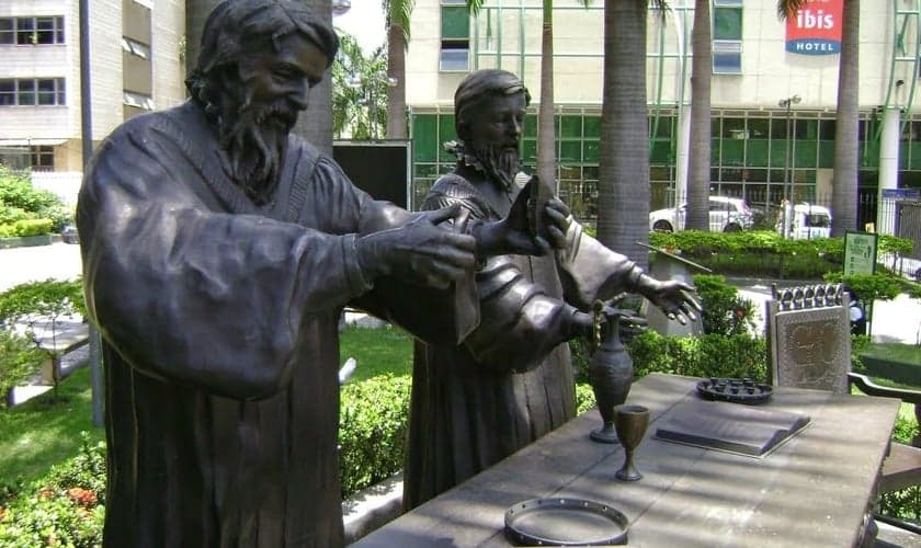 Escultura representando o primeiro culto protestante no Brasil, oficiado pelos pastores Rev. Pierre Richier e Rev. Guillaume Chartier. (Foto: Reprodução).