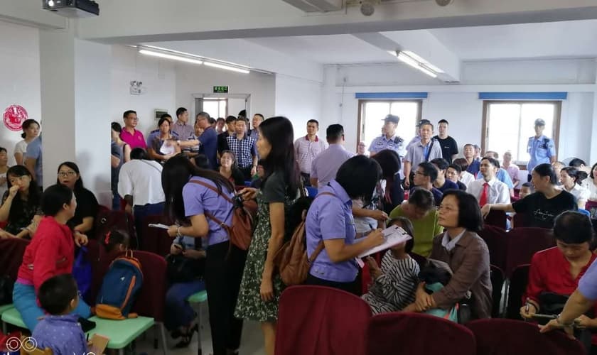 Agentes uniformizados coletam informações pessoais de cristãos que frequentam a Igreja Reformada da Bíblia em Guangzhou, em 15 de julho de 2018. (Foto: ChinaAid)