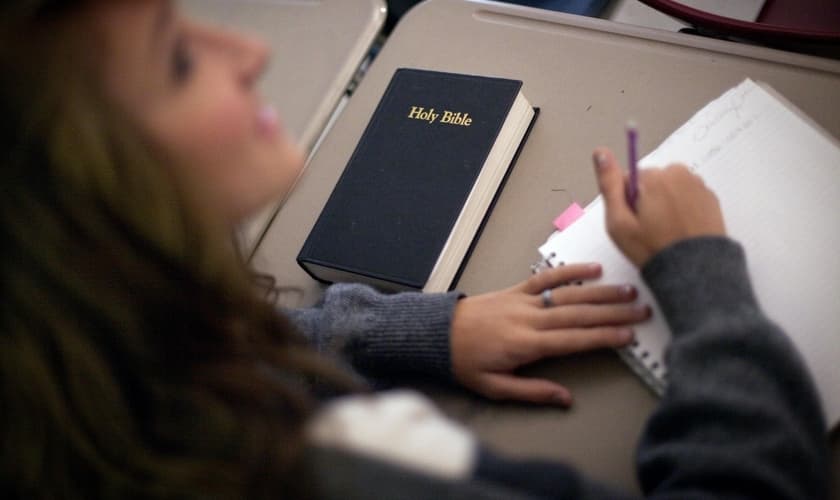 Imagem ilustrativa. Estudante com um exemplar da Bíblia em sua mesa na sala de aula. (Foto: Associated Press/David Goldman)