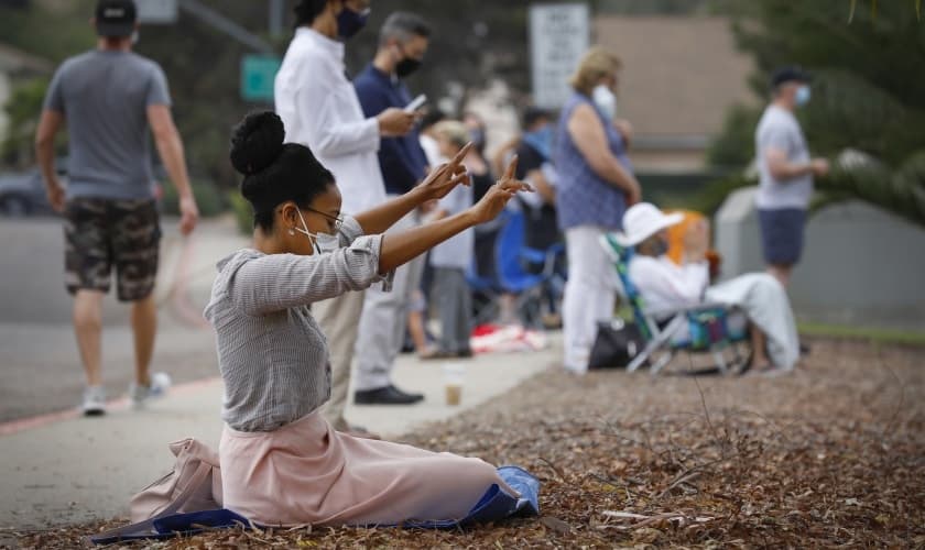 Mulher ora em frente ao colégio Mt. Carmel durante o evento “We Pray San Diego”, na Califórnia. (Foto: Nancee E. Lewis/San Diego Union Tribune)